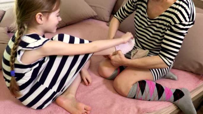 女人帮助女儿穿上袜子