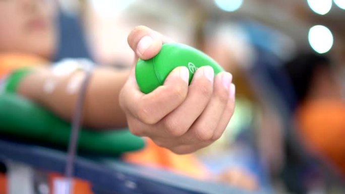输血献血者手持有弹性的绿球在医院为人类或病人捐献人体捐献志愿者。世界献血者日概念