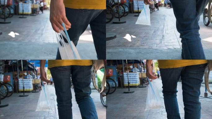 慢动作近距离手持塑料袋中的冰水在炎热天气晴天在街头市场行走