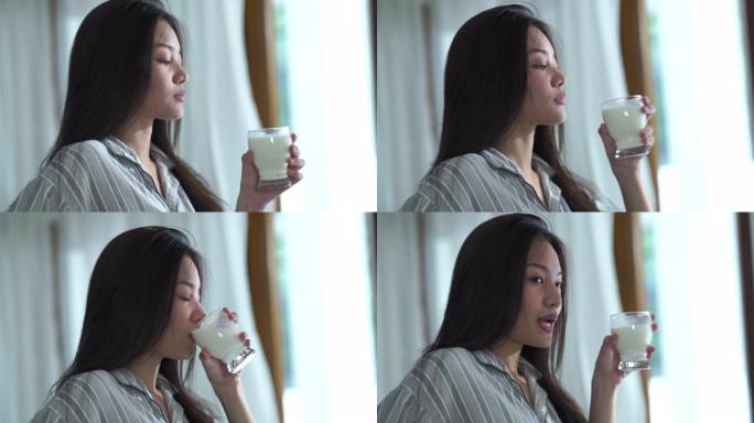 年轻女子在纯洁的早晨的面部表情，喝牛奶，舔嘴唇