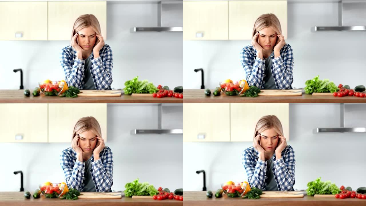 悲伤的年轻家庭主妇在厨房烹饪健康新鲜沙拉时头痛