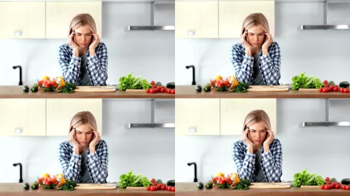 悲伤的年轻家庭主妇在厨房烹饪健康新鲜沙拉时头痛