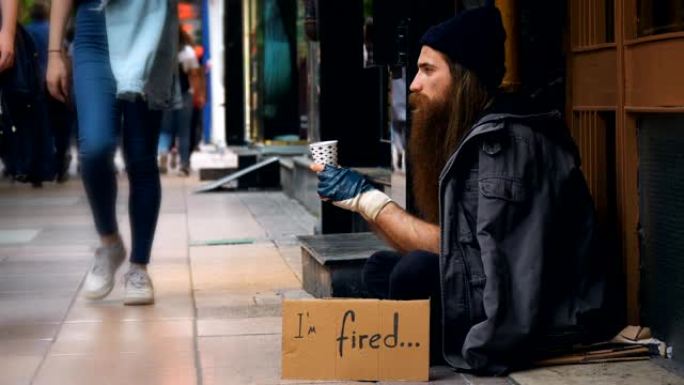 无家可归的人带着 “我被火了” 的纸板，在拥挤的街道上乞讨