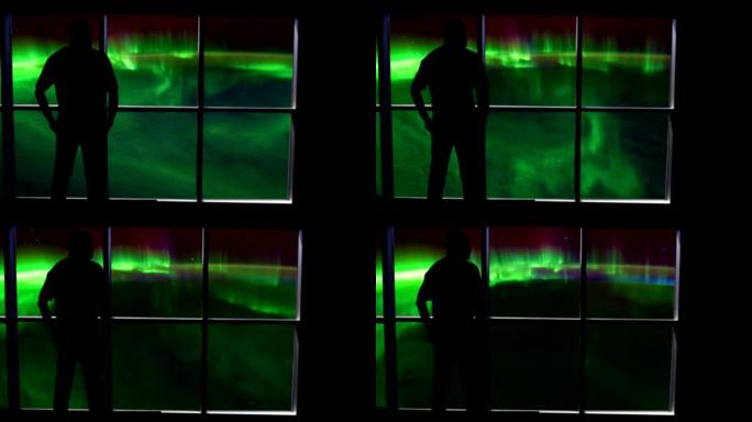 一个剪影的人站在窗户前，俯瞰着地球上的北极光。