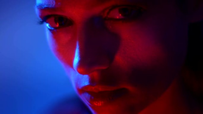 红色和蓝色霓虹灯的梦幻时装模特的特写镜头从底部到相机。