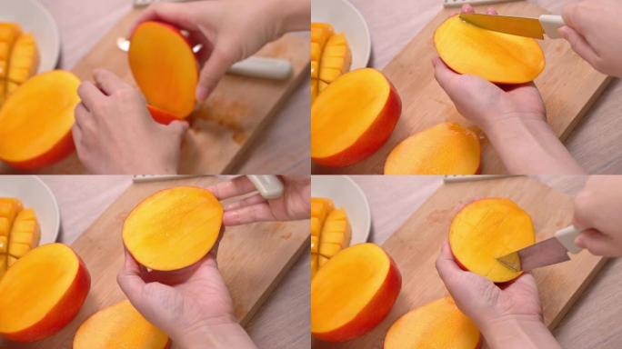 年轻女子正在切一个漂亮的新鲜多汁芒果，在厨房的木桌和砧板上吃。