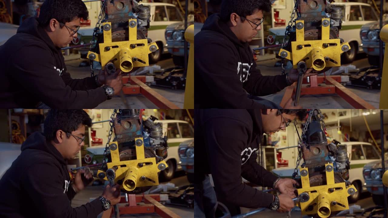 年轻的家庭机械师在汽车发动机上使用扳手