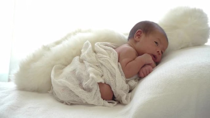 4k高角度视角中拍摄的亚洲新生女婴女儿躺在家庭卧室的白色床上和枕头上。无辜的新生婴儿保健概念。
