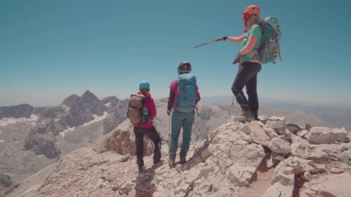 女登山队长在山顶给她的团队指路