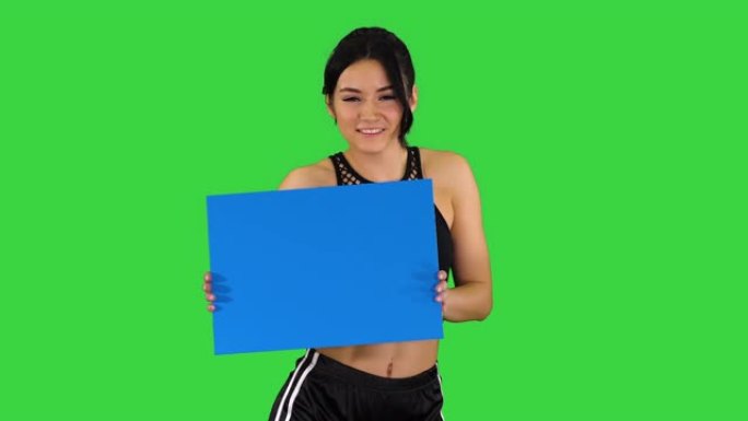 迷人的女孩拿着空木板，在绿色屏幕上跳舞，蓝色模型
