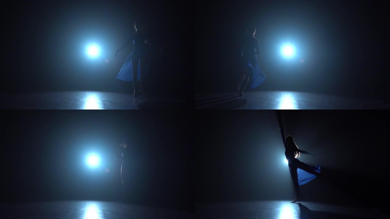 芭蕾舞女演员跳跃在工作室的聚光灯下绕圈奔跑。慢动作