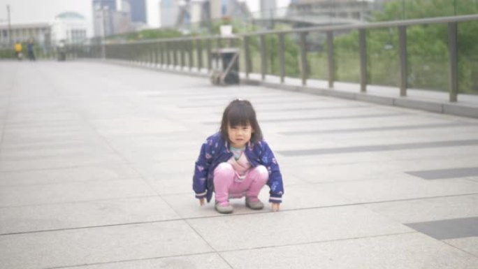 走在上海大街上的蹒跚学步的女孩