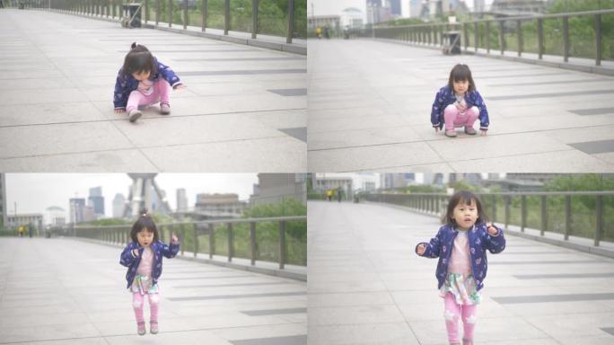 走在上海大街上的蹒跚学步的女孩