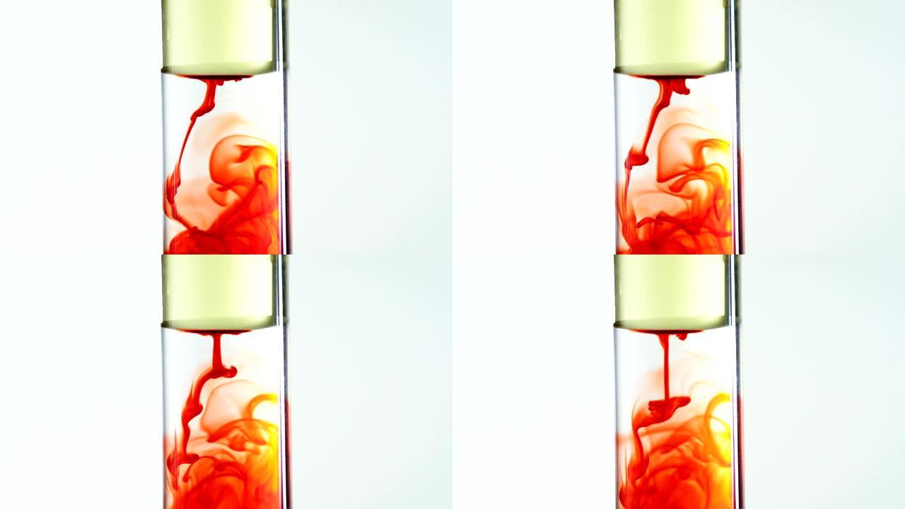 在透明试管中，红色食品colr墨水从油中滴入水中的视频片段