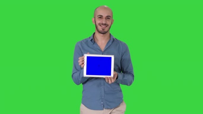 阿拉伯男子走路并展示平板电脑，在绿色屏幕上展示某些东西，色度键