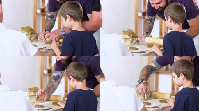 老师正在学习小男孩如何用粘土雕刻。
