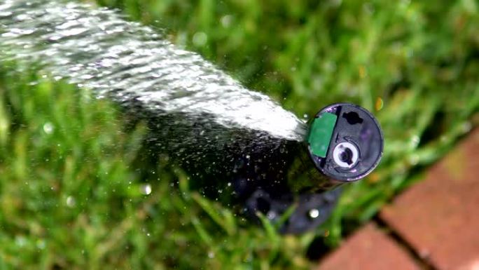洒水器，管道在绿色草坪上