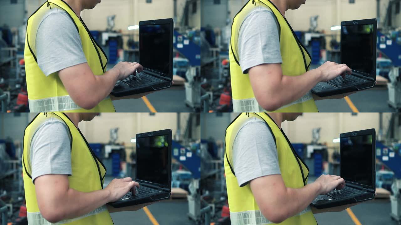 带安全帽的工业工程师在工厂使用笔记本电脑