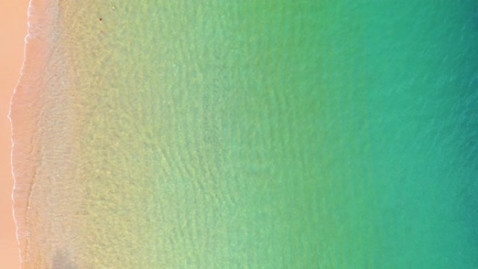 带绿宝石蓝色水和波浪泡沫的海滩鸟瞰图