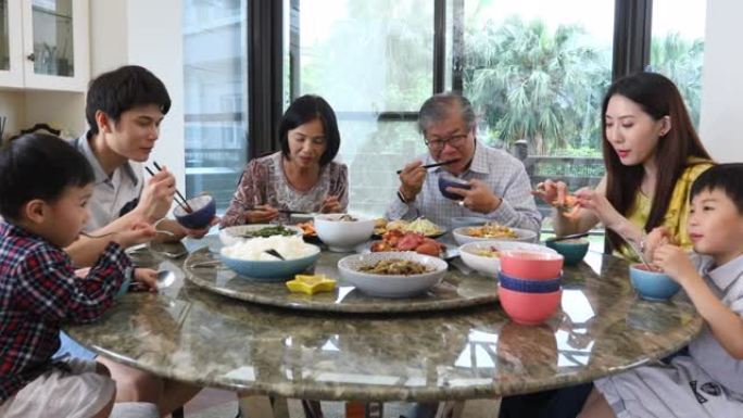 三代亚洲家庭在家服务和吃午餐