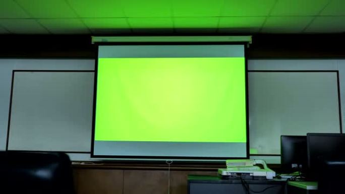 显示绿色色度键屏幕的投影仪屏幕场景站在计算机教室中。技术背景，技术背景的概念