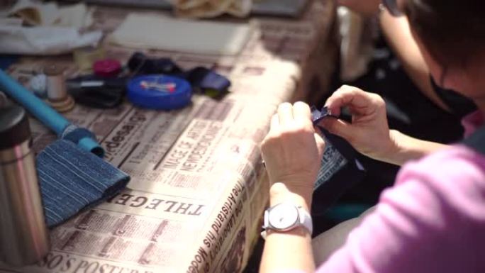 妇女在车间用针缝制拼布，手工制作和手工艺概念。