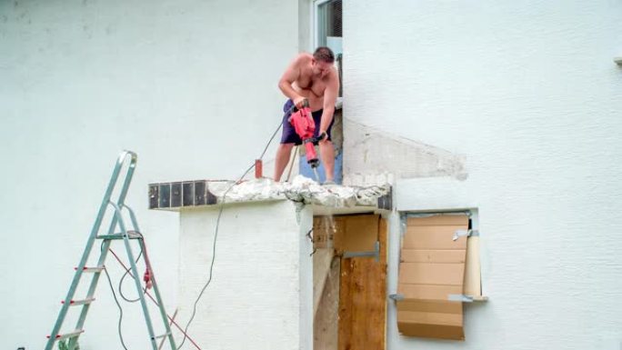 工人用手提钻摧毁混凝土突出的屋顶