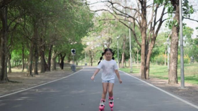亚洲小女孩在公园的路上玩滑旱冰。活动假期的概念，学习发展和生活体验。4K分辨率和慢镜头。