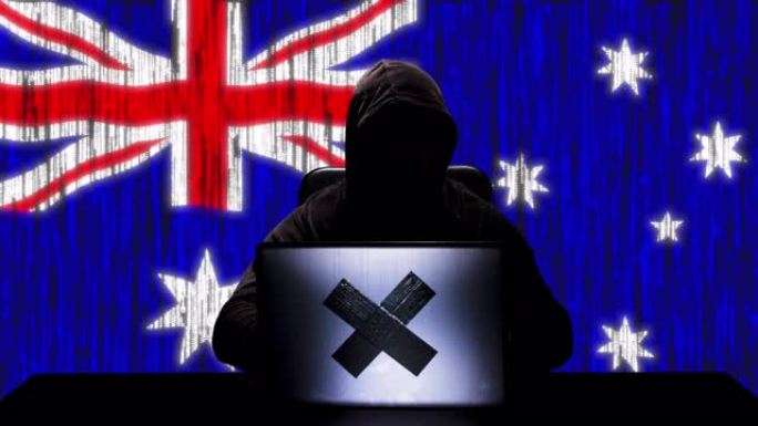 黑客在笔记本电脑上键入代码黑客的剪影，背景是澳大利亚国旗