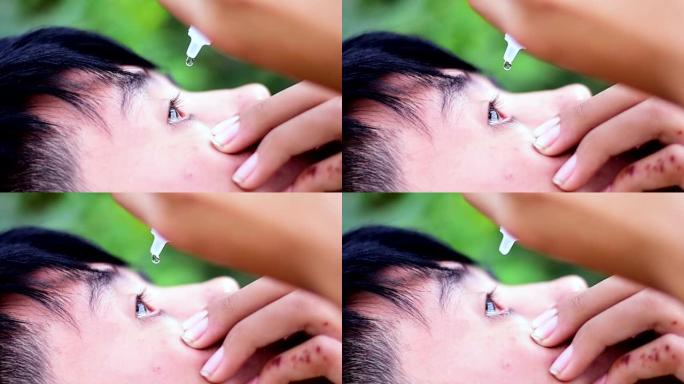 男孩滴眼药水治疗他的眼痛，保健眼药概念