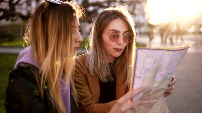 两个穿着休闲秋装的时尚女孩游客，在新城市享受他们的冒险。旅游指南，和朋友一起在欧洲旅游。一起看地图，