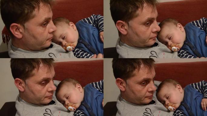 疲倦的父亲让他六个月大的男婴入睡