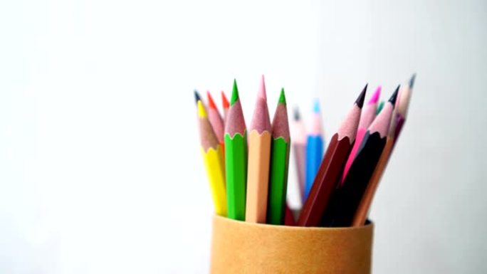 旋转彩色铅笔在灰色背景上的旋转铅笔棕色盒盒。黑人上学，为教育写作。4k