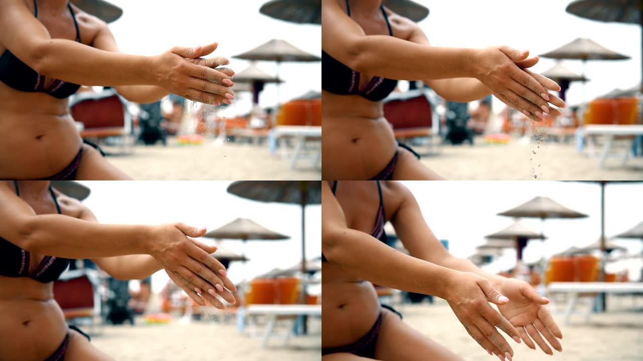 穿着比基尼的迷人女人在慢动作中从沙滩上干净的手