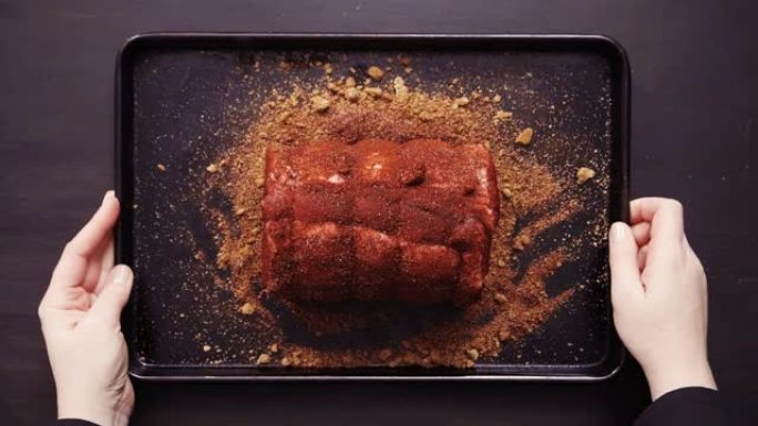 厨师擦香料擦无骨猪肉烤肉。
