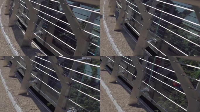 市内人行天桥的一部分。金属和玻璃栏杆，以确保人们的安全。特写