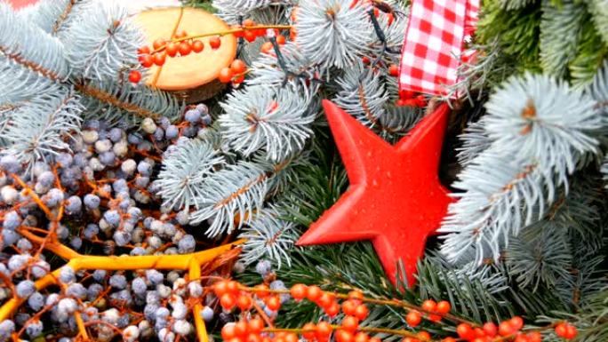 红色云杉树枝上漂亮的圣诞树玩具，在浆果的红色树枝旁边是星星的形式