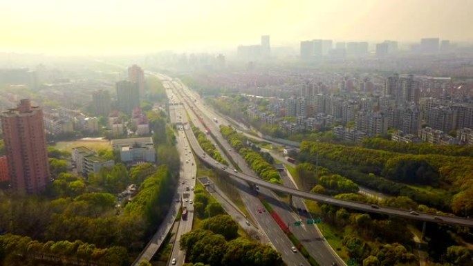 高速公路路口绿树成荫的汽车鸟瞰图。建筑结构和交通概念中的桥梁道路或街道。顶视图。中国上海中午的城市。