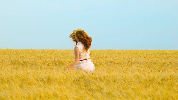 年轻快乐的红头发女人在麦田里慢动作跳跃和奔跑