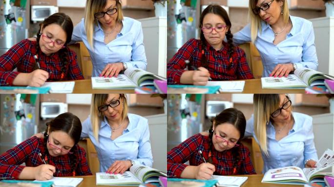迷人的年轻女子和她可爱的小女儿坐在桌子旁，一起做作业。母亲帮助女儿上学校的课。