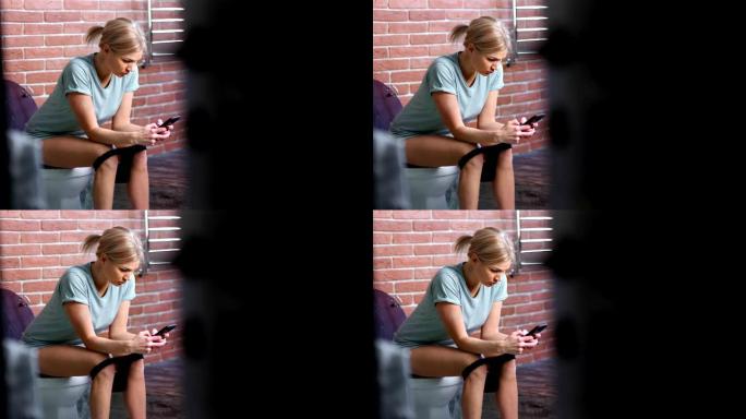 美丽自信的年轻女子坐在马桶上聊天使用智能手机中远镜头