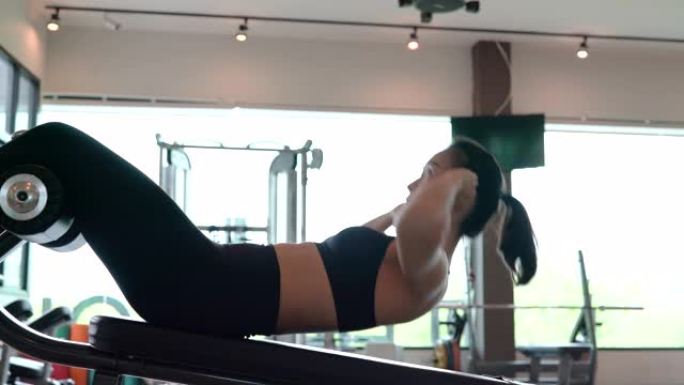 专业美丽的亚洲女性锻炼在健身馆做仰卧起坐运动健康的生活方式，运动员腹肌肌肉强健，适合身体4k分辨率。