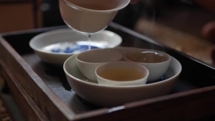 茶师将绿茶倒入茶杯中，以供盖碗或钟。中国传统功夫或功夫茶道。中国传统文化的元素。特写。4k