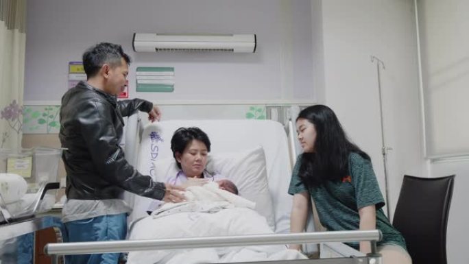 新生儿和家人躺在医院的床上。