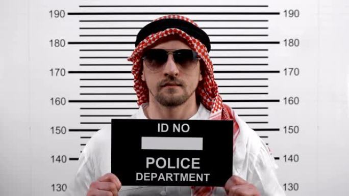 一个戴眼镜的阿拉伯人在警察局的面部照片…