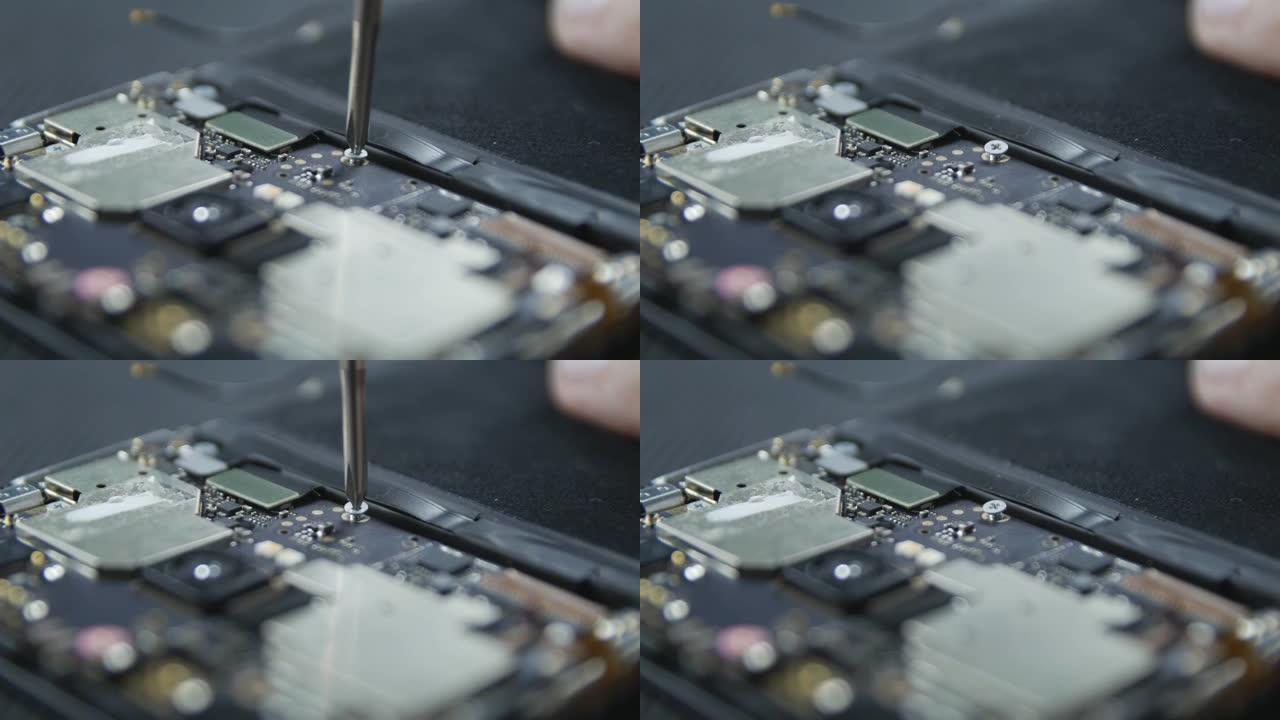 显示手机维修过程的特写镜头。修理工用螺丝刀拧出螺丝。智能手机的内部组件。拆解的手机。