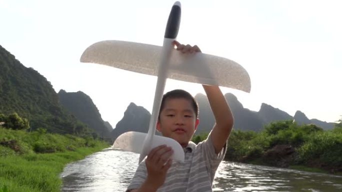 亚洲男孩在户外玩模型飞机