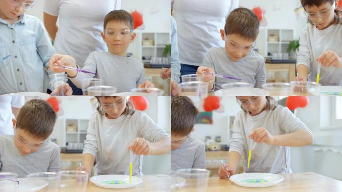 DS儿童使用滴管将颜色滴到盘子上进行科学实验
