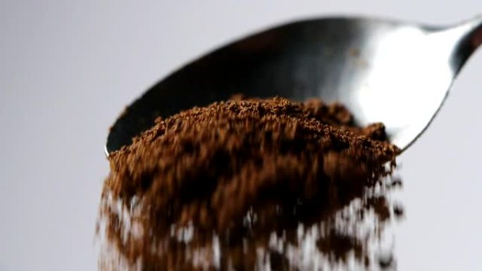 一汤匙咖啡。咖啡粉从勺子中缓慢落下
