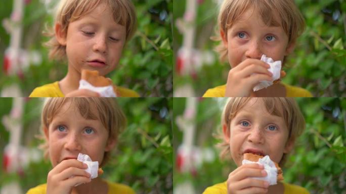 一个小男孩在街头市场上吃美味煎饼的特写镜头。街头美食概念